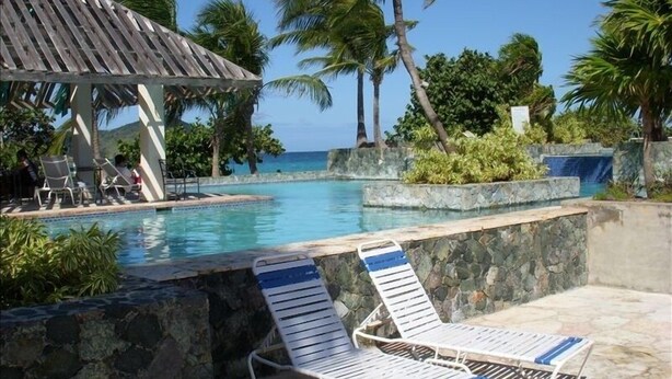 Ein Poolbereich mit Liegestühlen und einer Laube.