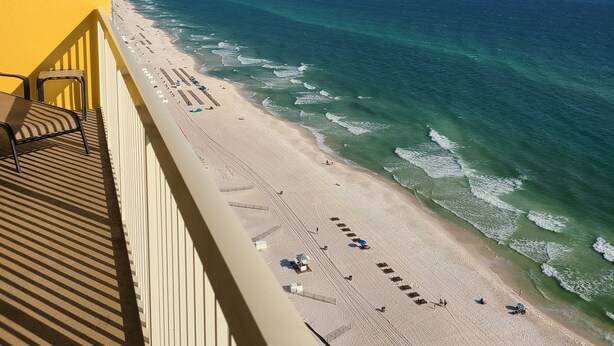 A balcony with a view of a beach and ocean.