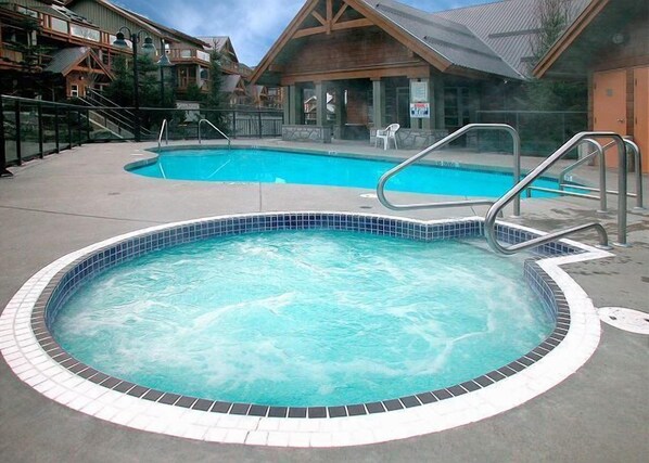 Ein Whirlpool mit einer gefliesten Kante, umgeben von einer Betonplattform.