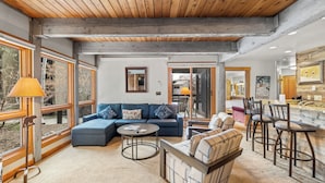 A modern living room with a sectional sofa, a round coffee table, and a bar area with stools. - Walk to the Gondola | Pool and Hot Tubs | The Lodge at Steamboat! (Steamboat Springs)