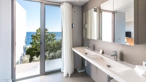 A modern bathroom with a large window, a white sink, and a mirror. - St Barts New Luxury Villa Roc E Mar, Fantastic Ocean View, Large Pool, Exclusive (TOINY)
