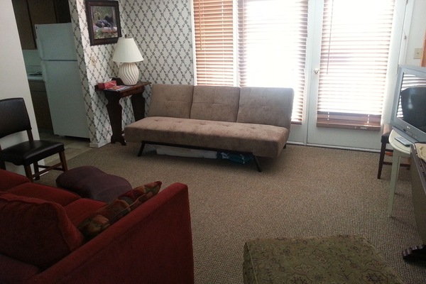 View of Living room with 1 couch, 1 futon, and one large ottoman chair. Relax!