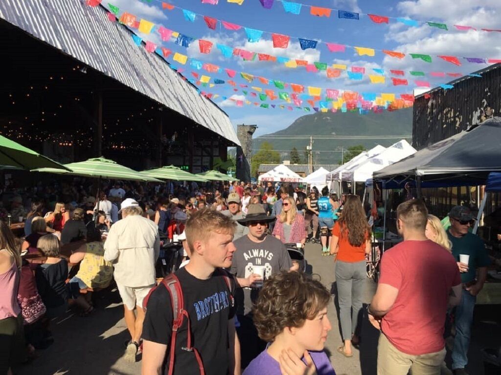A crowded outdoor market with tents and people walking around.