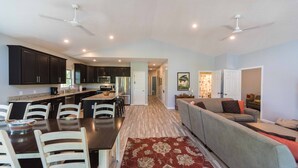 A modern kitchen with dark cabinets, a dining table with chairs, and a red patterned rug. - Built in 2017 - 4 BR/3 BA Lakeview in Grand Rivers - The Only City on Both Lakes (Grand Rivers)