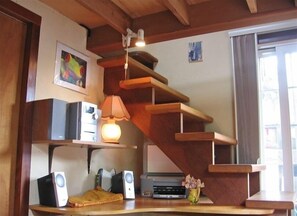 Cozy retreat with a unique staircase shelf, desk area, and natural light.