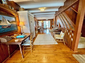 Un intérieur en bois comprenant un coin repas, un escalier et une vue sur l’extérieur.