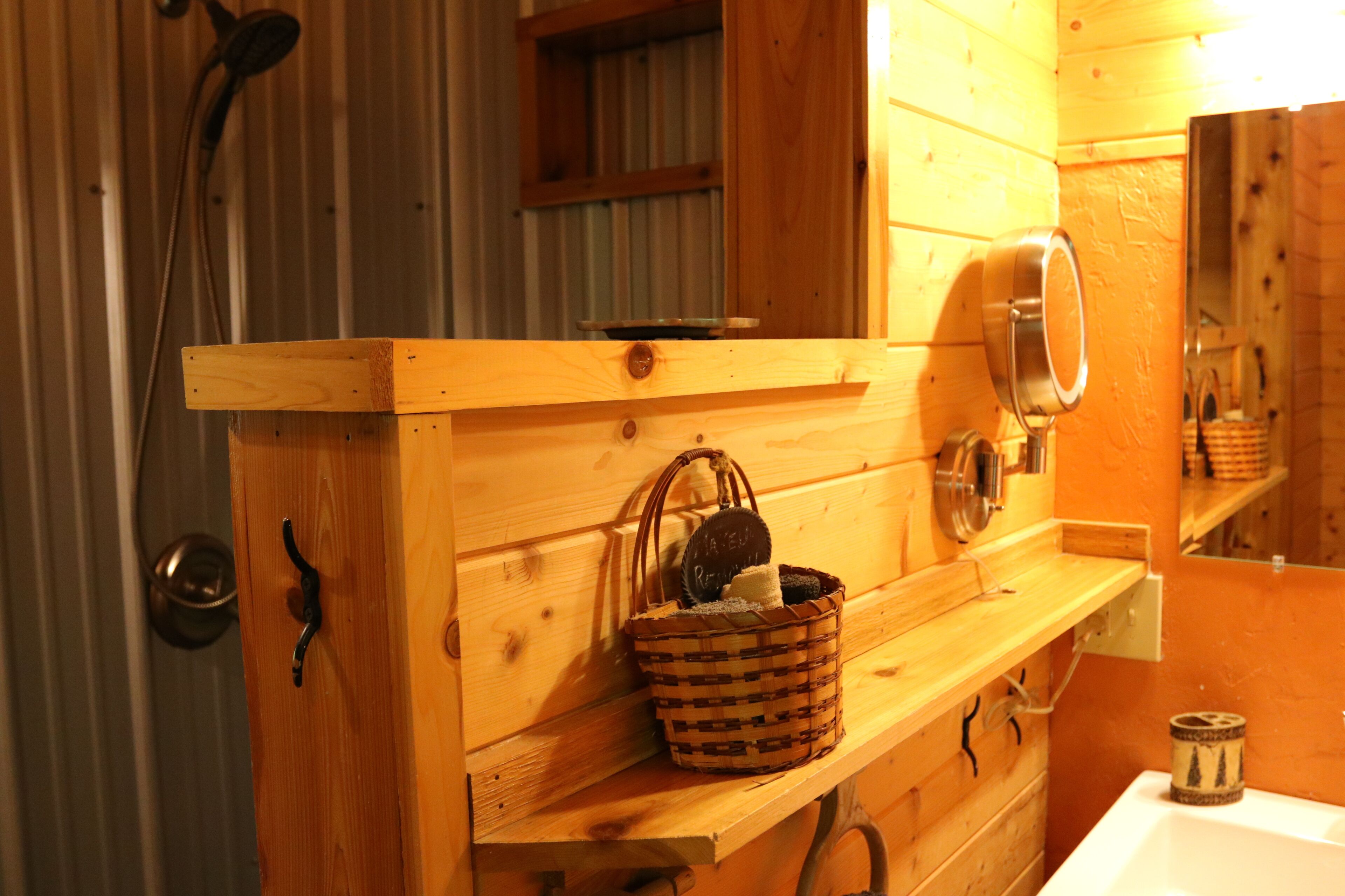 A wooden bathroom vanity with a mirror, a basket, and a towel rack.