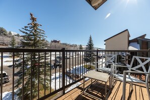 A wooden deck with a view of a snowy landscape and a building in the background.