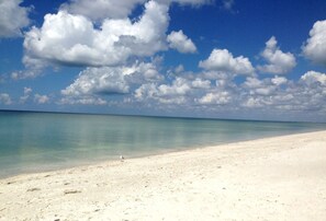 Ranta lähistöllä, aurinkotuoleja, rantapyyhkeitä