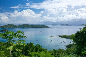 A coastal landscape with clear blue waters, green hills, and several boats anchored near the shore. - Couples Retreat, Sweeping VIEWS, Kayaks Await at the Beach! (St. John)