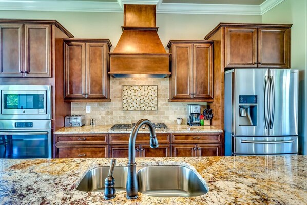 A kitchen with wooden cabinets, stainless steel appliances, a granite countertop, and a backsplash. - 2nd House Built For Groups - 4 Suites, 8 Beds, WOW (Prattville)