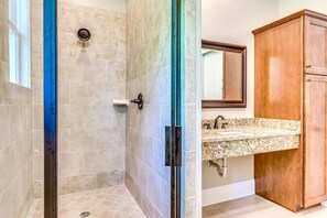 A bathroom with a shower, a sink, and wooden cabinets. - 2nd House Built For Groups - 4 Suites, 8 Beds, WOW (Prattville)