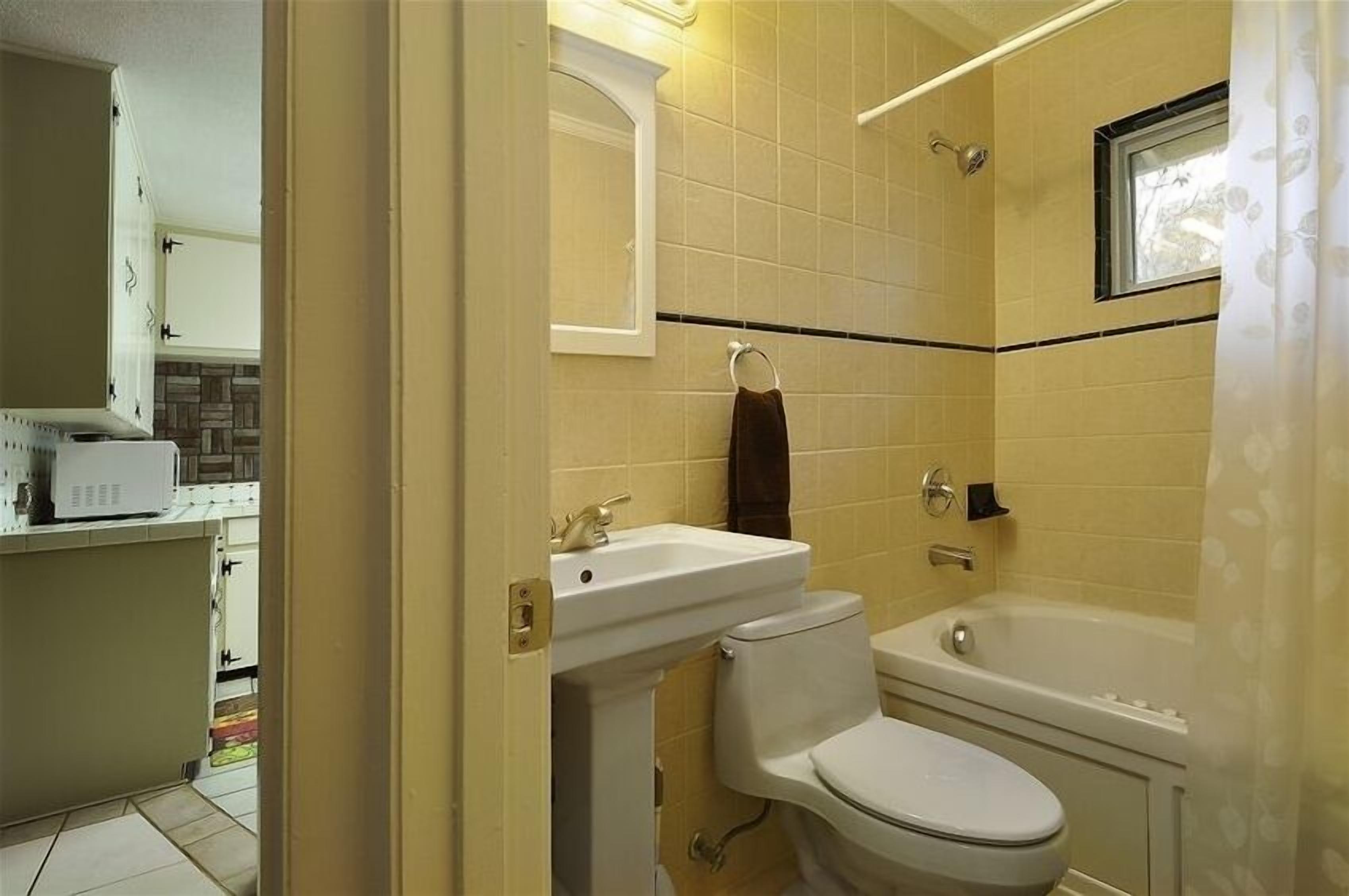 A bathroom with a toilet, sink, and bathtub.