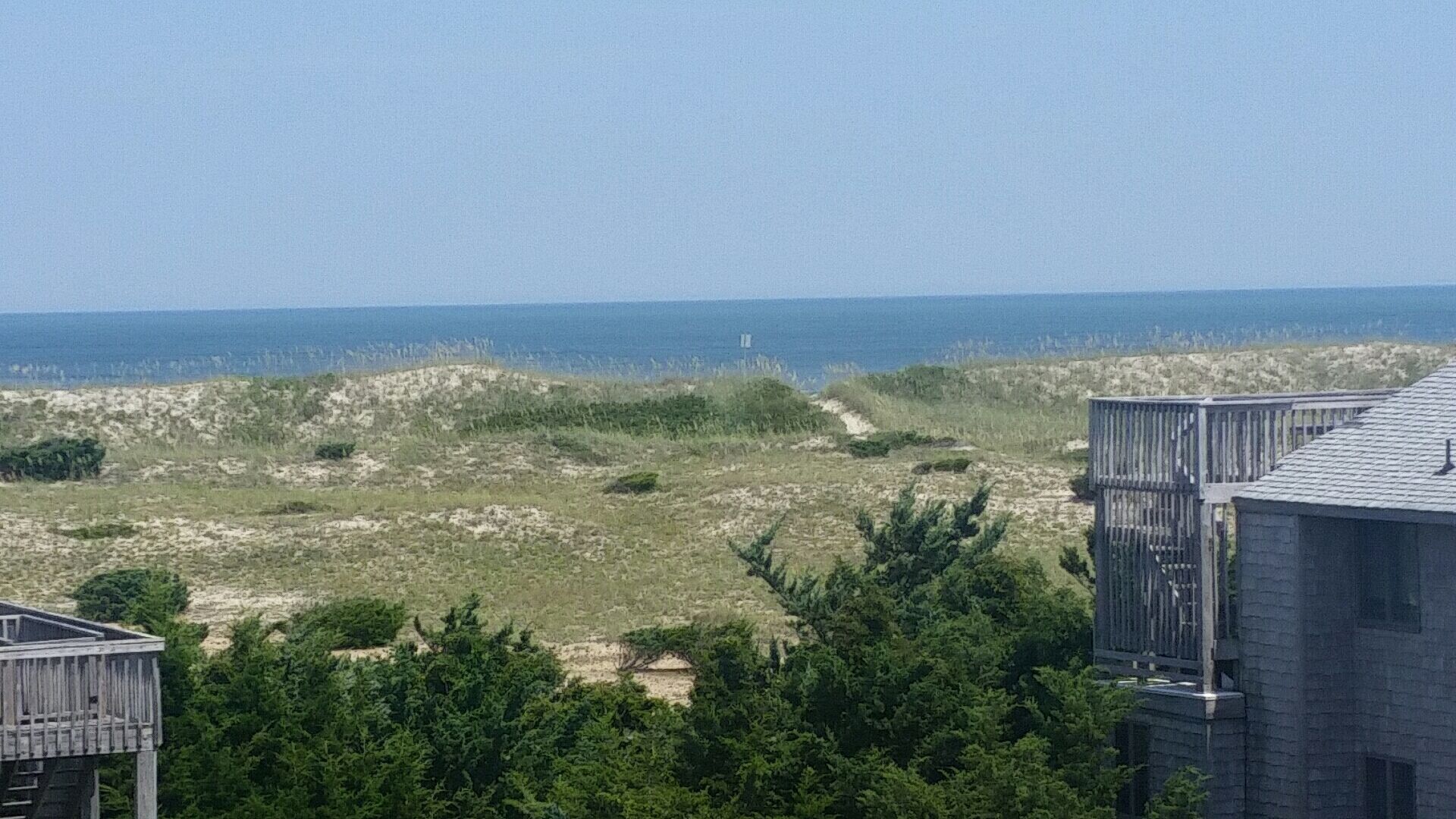 Un paisaje costero con una playa arenosa, dunas y vistas al mar.