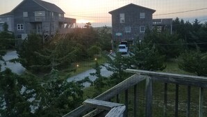 A residential area with two wooden houses, a wooden deck, and a car parked in front. -  TOP DECK OCEAN VIEWS HOTTUB
 
 SHORT STROLL  BEHIND  HOUSE 
    TO SERENE BEACH (Salvo)