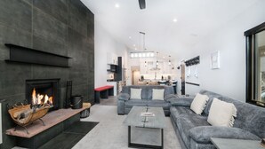 A modern living room with a fireplace, grey sofa, and a coffee table.