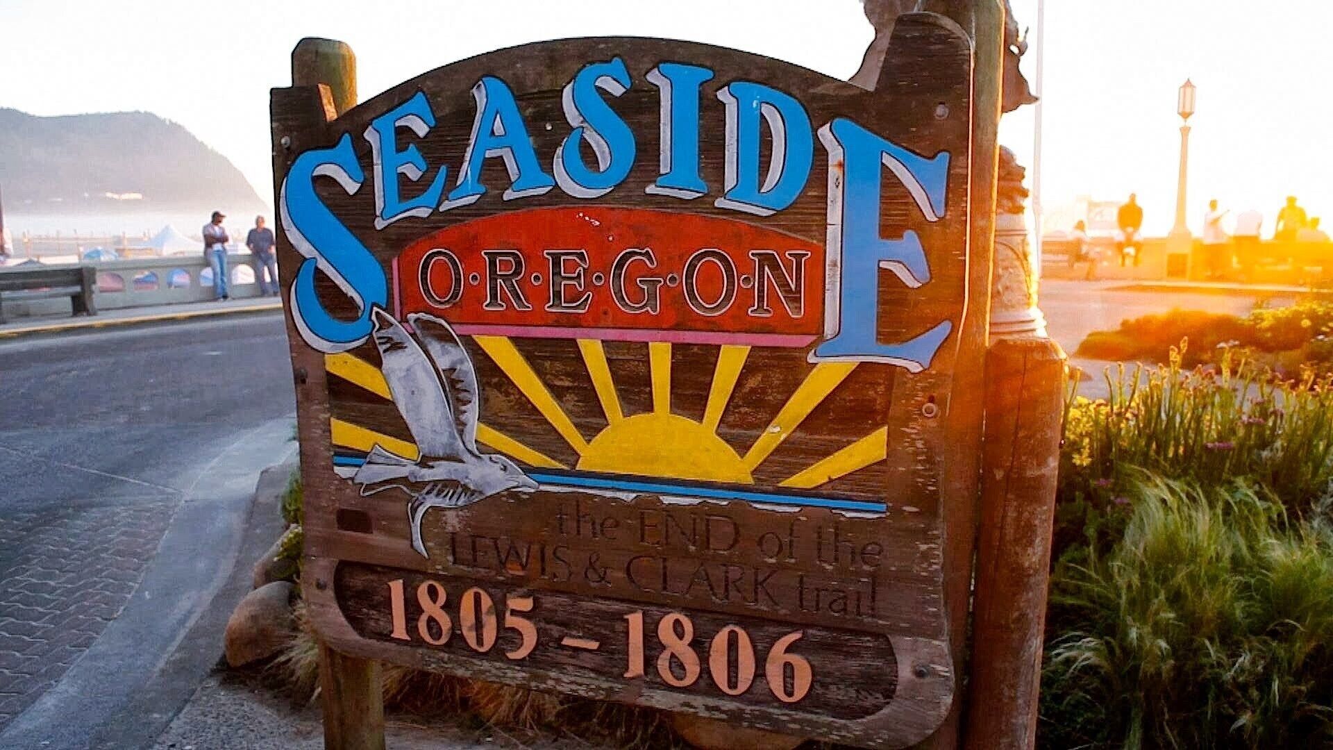 A wooden sign with the text "SEASIDE OREGON" and a bird illustration.
