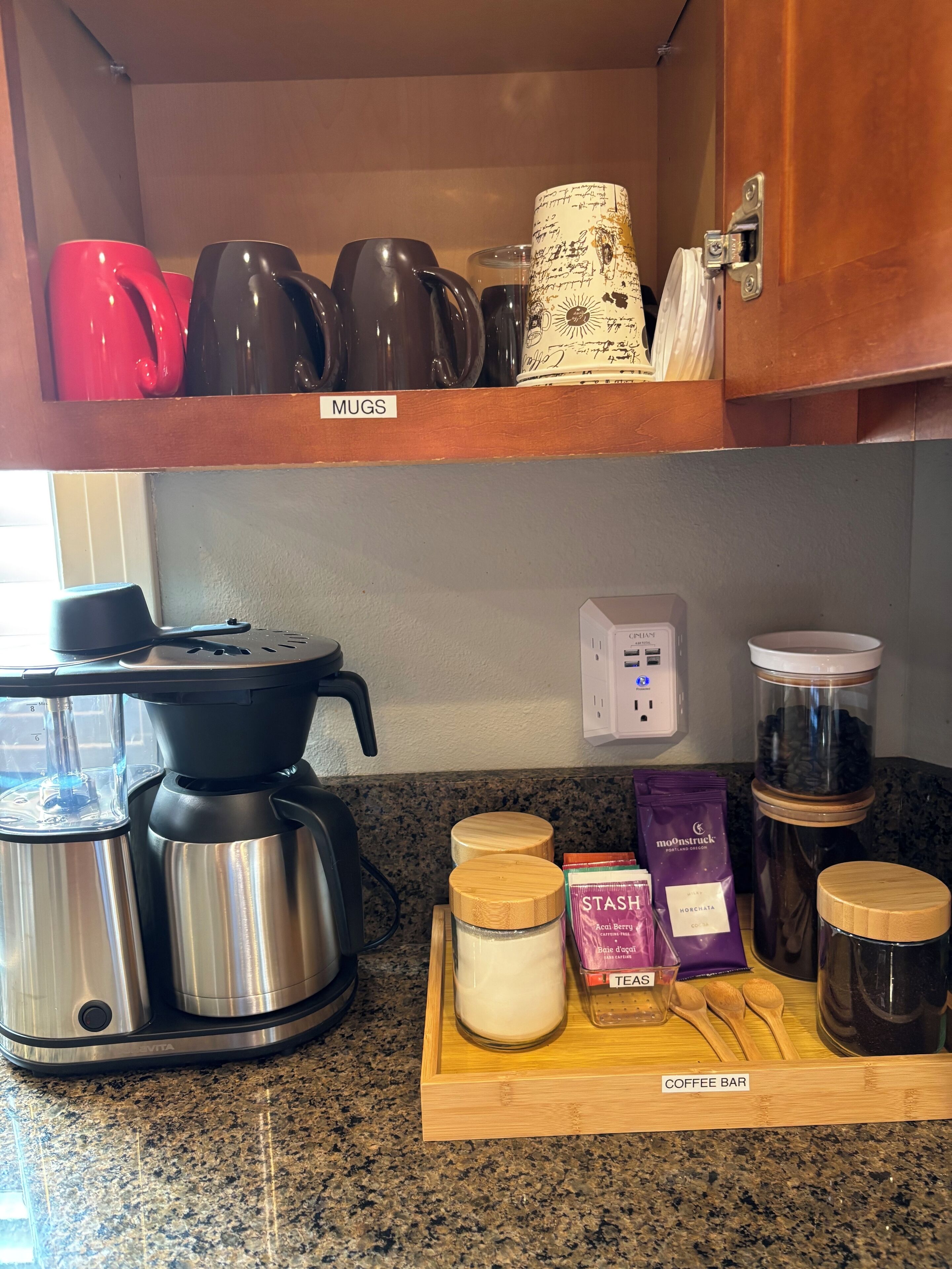 Une cuisine équipée d’une machine à café, de tasses et de grains de café.