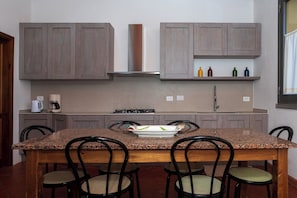 A kitchen with granite countertops, wooden chairs, and a central island. - Villa between Florence  Siena and Pisa. 1 km to village.  A/C in all rooms-Wi Fi (Montespertoli)