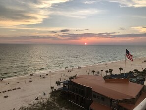 Vista sulla spiaggia con una bandiera americana, spiaggia sabbiosa e un edificio con tetto rosso.