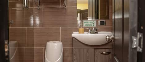 Un baño moderno con inodoro, lavamanos y espejo.