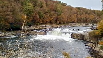 A waterfall cascading over rocks in a forested area.