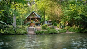 A cabin with a wooden deck and a stone staircase leading to a dock over a river. - ROMANTIC TROUT FISHING CABIN - WiFi, HotTub FirePit, Blue Ridge, RiverMistCabin (Epworth)