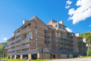 A multi-story hotel with balconies, a parking garage, and a view of the surrounding area.