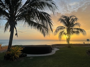 Sonnenuntergang mit Palmen und Strand.