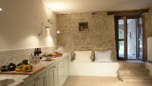 A kitchen with stone walls, a wooden countertop, and a view of the outside. - Totally Private18th Century Stone Villa with 15mt heated Pool (Monte Castello di Vibio)
