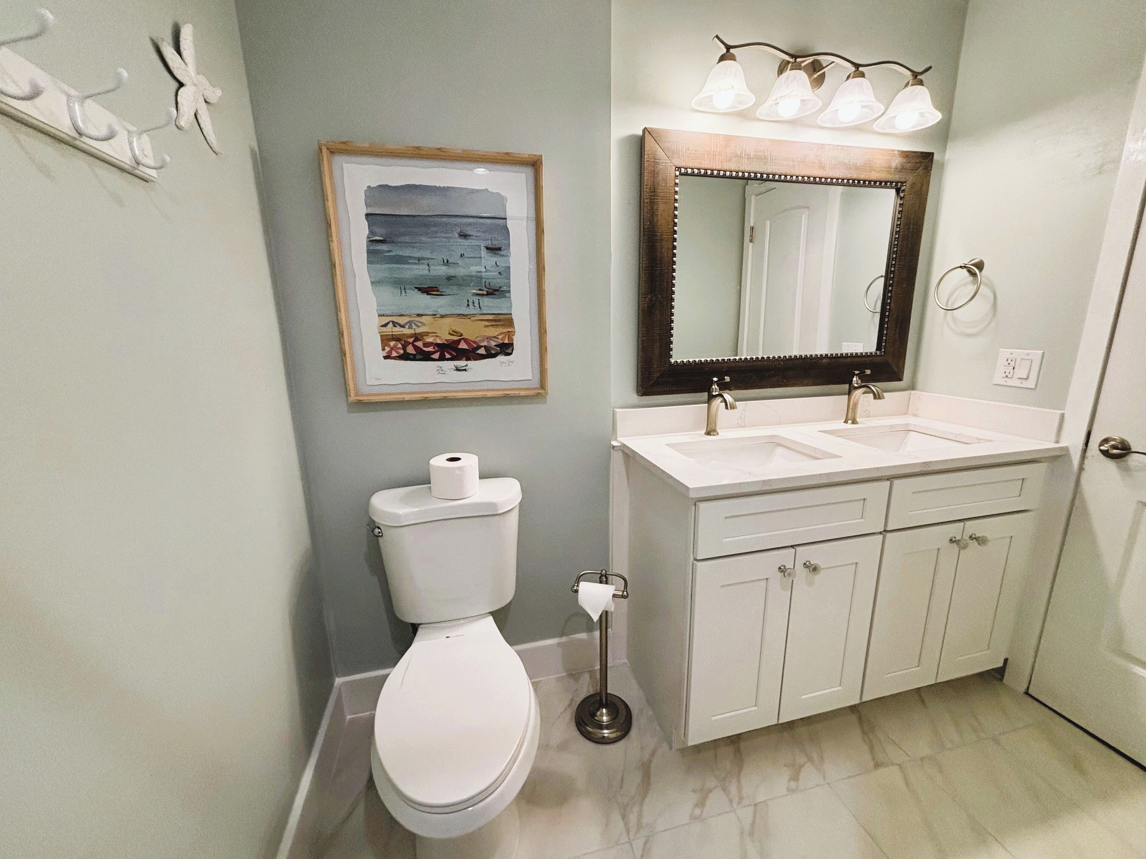 A bathroom with a toilet, sink, and mirror.