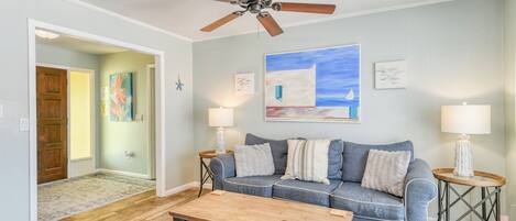 A living room with a sofa, coffee table, and two side tables with lamps.