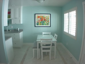 Enjoy meals in this cozy kitchen with a dining table and chairs, a perfect space for sharing meals together.