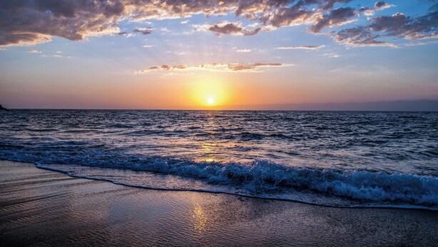 A sunset over the ocean with waves on the shore. - Light and bright beach retreat (Carlsbad)