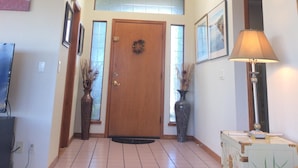 A hallway with a wooden door, a ceiling fan, and a lamp. - Mandolin Wind - Private retreat with filtered ocean view and hot tub (Bodega Bay)