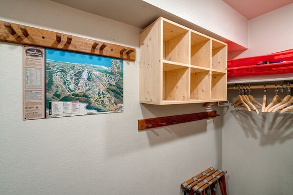 Une pièce avec un meuble en bois, une carte et un kayak rouge.