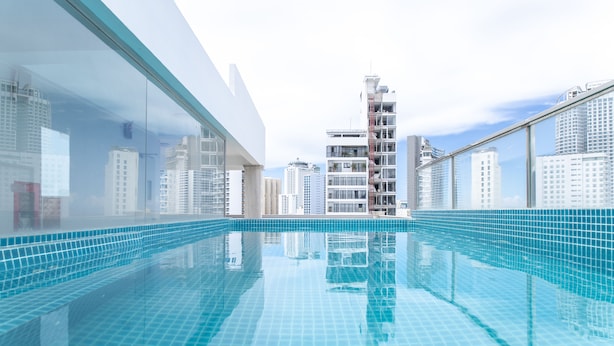 A modern indoor swimming pool with a clear view of surrounding high-rise buildings. - Seven Seas Hotel and Apartment (Nha Trang)