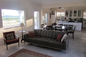 The living, dining, and kitchen areas open to the gallery-style front porch.