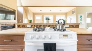 A modern kitchen with a white stove, a digital clock, and a wooden countertop. - Spacious Studio Apartment Minutes from Downtown, Private Parking  (Seattle)