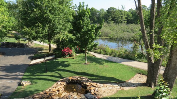 A well-maintained garden with a stone fire pit, a pond, and a walking path. - 10 Minutes from Downtown Memphis -  Southern Luxury in this Spacious Home (Marion)