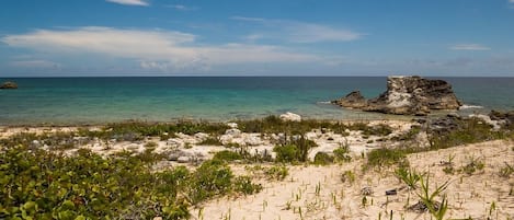 Na praia, espreguiçadeiras, toalhas de praia 