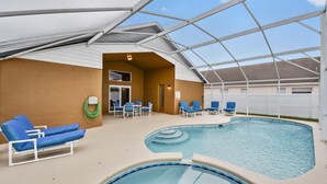An indoor swimming pool with blue lounge chairs and a covered seating area. - Coca Cola Villa, Private South-Facing  Pool & Spa, 3 Miles to Disney (Kissimmee)