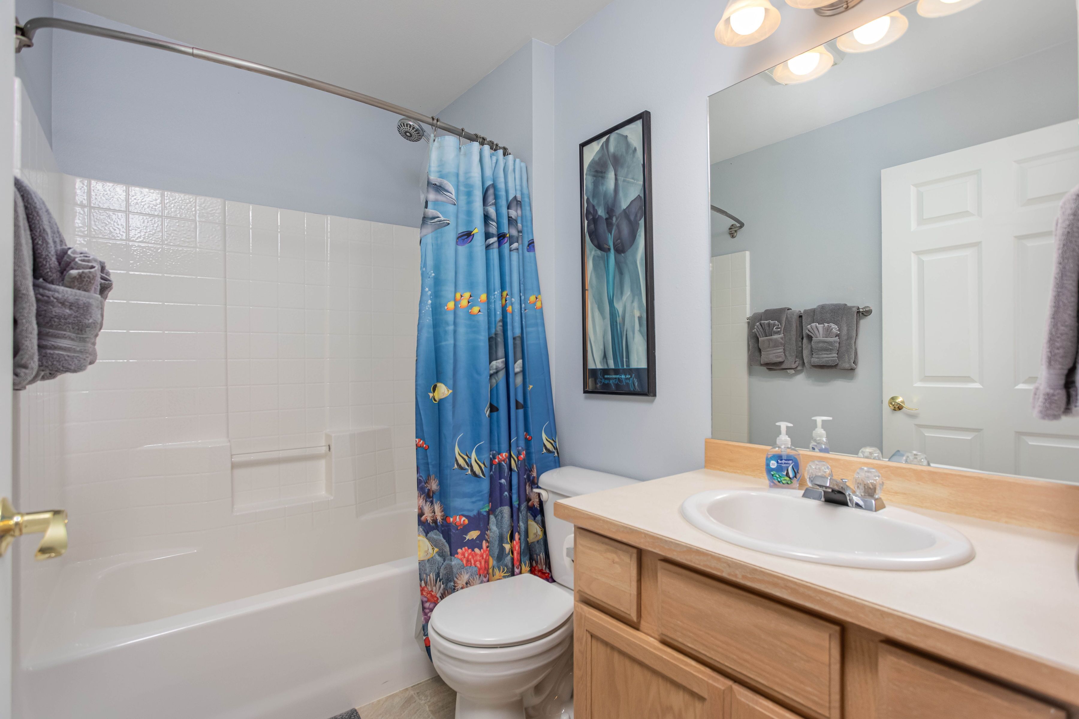 A bathroom with a bathtub, toilet, and sink.