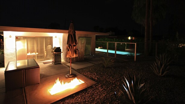 A modern outdoor patio with a fire feature, a seating area, and a pool. - Iconic Mid-Century Alexander Home in Palm Springs w/ Pool & Spa (Palm Springs)
