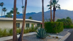 A modern building with a flat roof, surrounded by palm trees and a mountain backdrop. - Iconic Mid-Century Alexander Home in Palm Springs w/ Pool & Spa (Palm Springs)