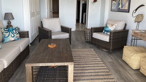 A living room with wicker furniture, a ceiling fan, and a framed abstract painting. - Relaxation Station!  Enjoy a very quiet, calm area of Myrtle Beach at our condo. (Myrtle Beach)