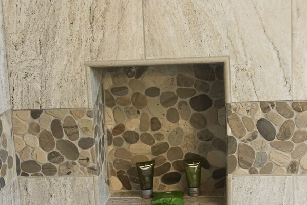 A stone wall with a small alcove containing two green bottles and a green cloth. - Large Ocean View Home with Optional Guest Quarters Close to Beach 4 Large Decks (Oceanside)