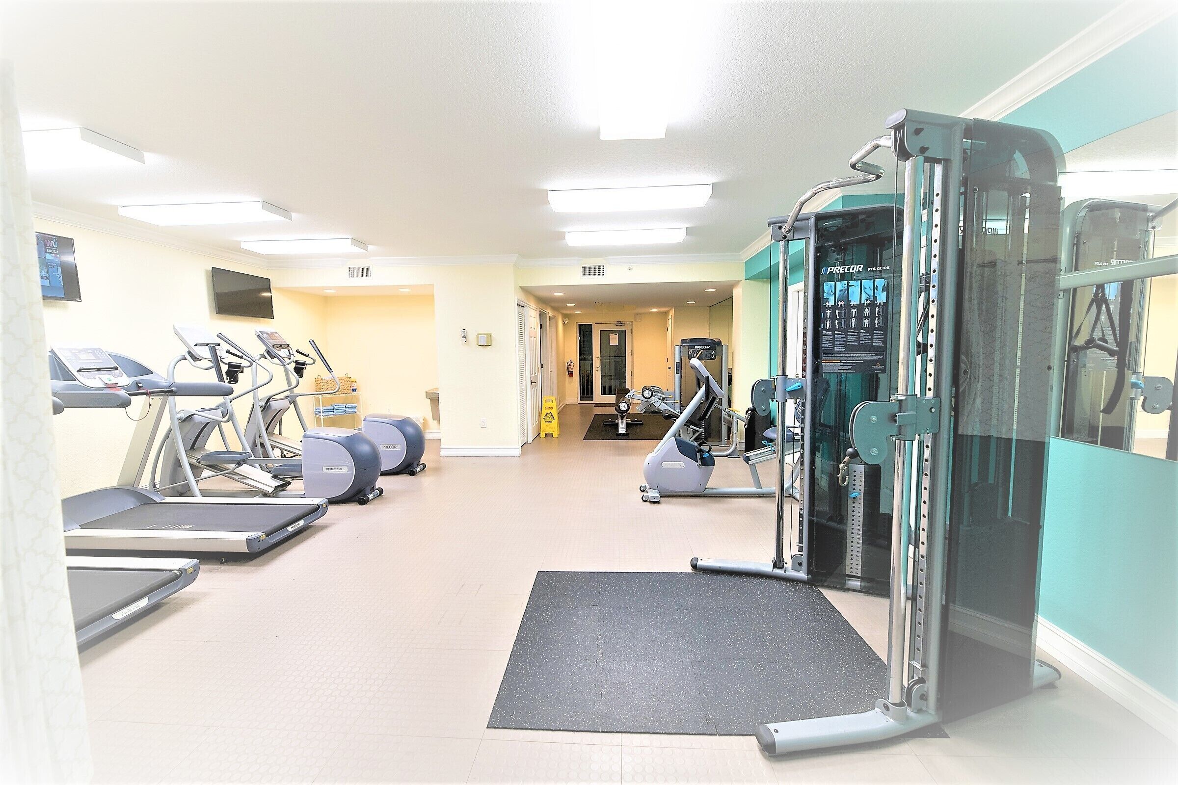 A gym with treadmills, elliptical machines, and weightlifting equipment.