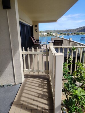 Enjoy a serene view of the coastline from this balcony, featuring a comfortable seating area with chairs and a table.