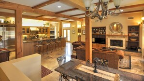 Un amplio salón con chimenea, una mesa de comedor y una cocina con barra.